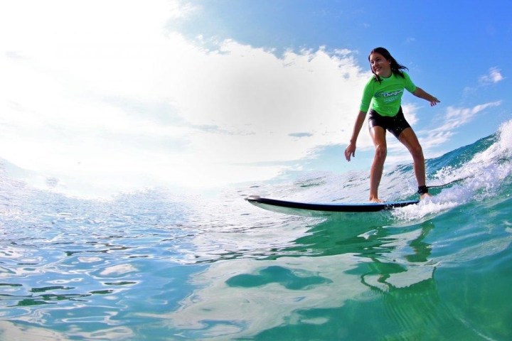 a girl riding a wave on a surfboard in the water