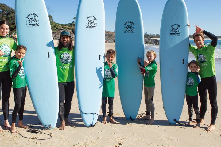 a group of people standing on a beach posing for the camera