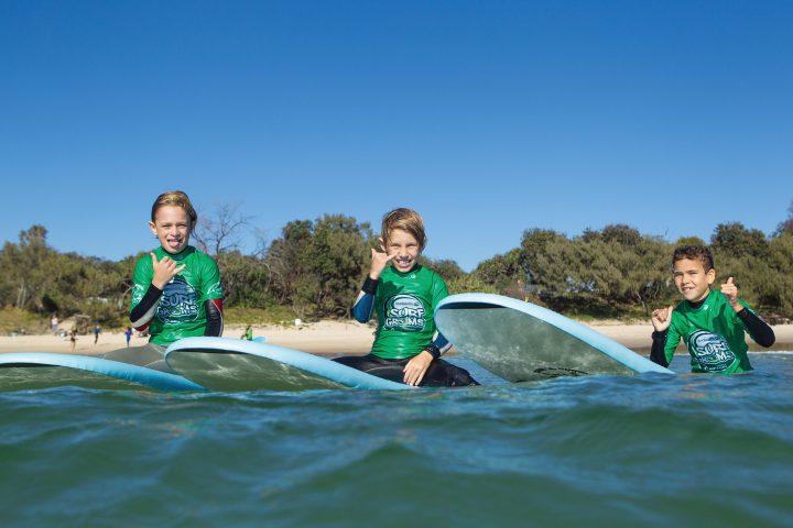 a young girl riding a wave on a surfboard in the water