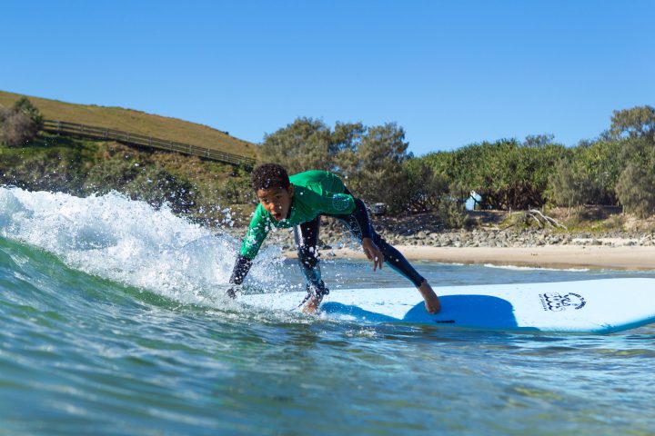 a man riding a wave on a surf board on a body of water